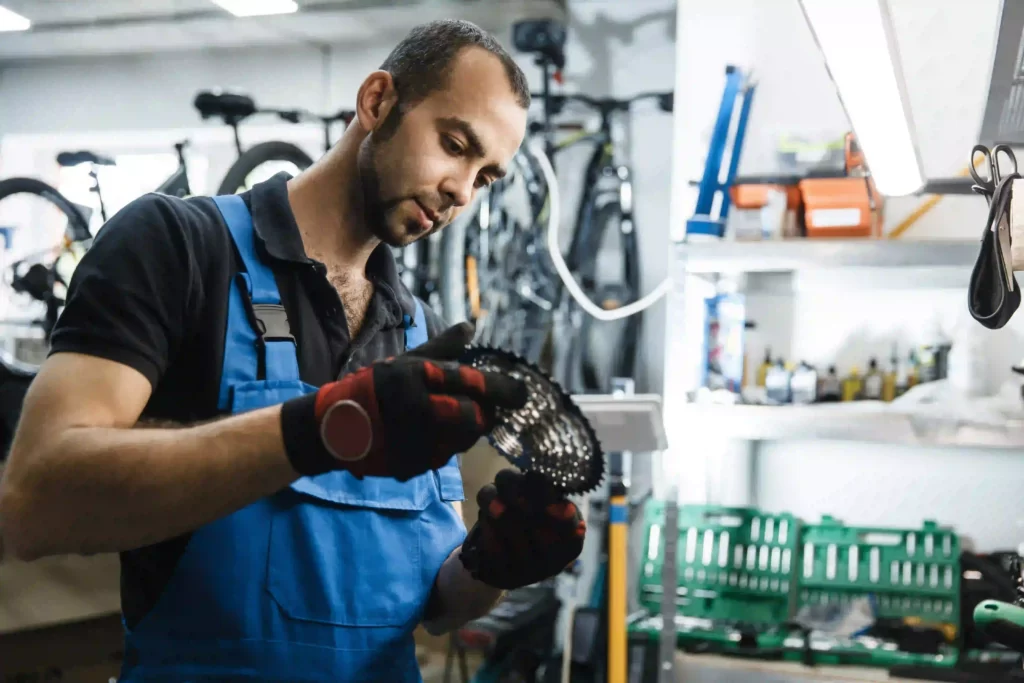 Mécanicien tenant une cassette de vélo dans la main